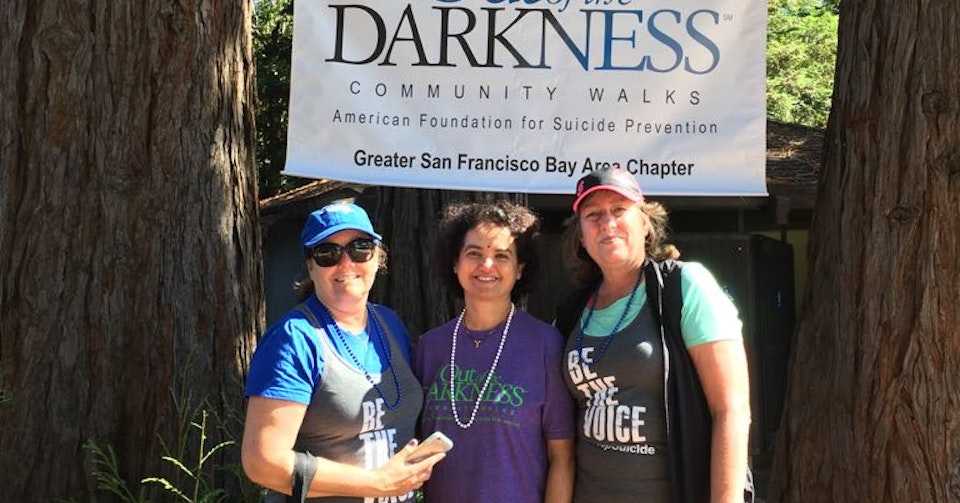 Walkers in front of Out of the Darkness sign